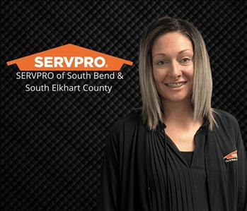 woman smiling at camera with black background and servpro logo